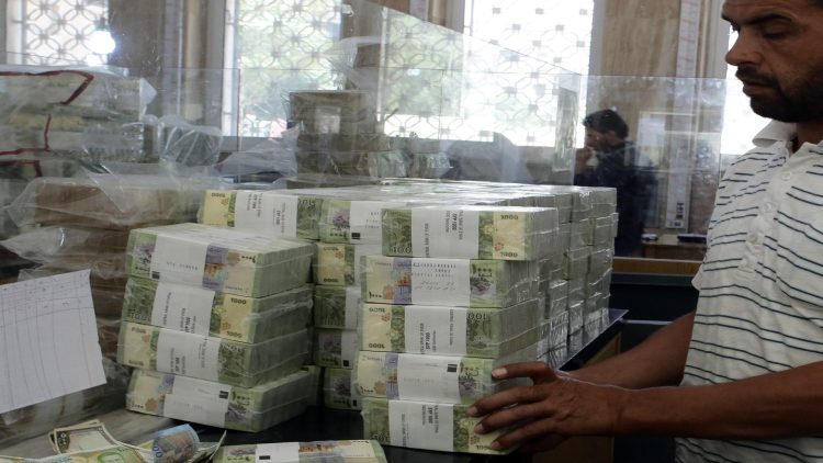 A bank official stacks bundles of new Syrian 1000 pound bank note, on June 30, 2015, following its release by the Central Bank of Syria in Damascus to reinforce the local currency and resist counterfeiting. AFP PHOTO/ LOUAI BESHARA        (Photo credit should read LOUAI BESHARA/AFP/Getty Images)