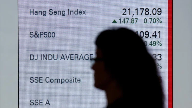 ظل سيدة أمام شاشة الأسهم الصينية في هونغ كونغ