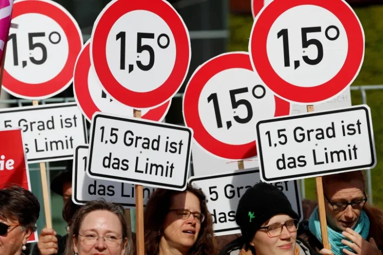 ناشطون بيئيون يتظاهرون في برلين ويحملون لافتات تطالب بالإبقاء على درجة حرارة الكوكب في حدود 1.5 درجة مئوية (رويترز)